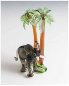 Glasfigur, Elefant unter zwei Palmen, Murano, Italien, farbig staffiert. H. ca. 14,5 cm, Br. ca. 9,5