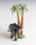 Glasfigur, Elefant unter zwei Palmen, Murano, Italien, farbig staffiert. H. ca. 14,5 cm, Br. ca. 9,5