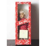 Käthe Kruse-Puppe, Mädchen mit kurzen blonden Haaren und braunen Augen, mit rot geblümtem Kleid