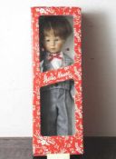 Käthe Kruse-Puppe, "Fraule", Junge mit braunen Haaren und blauen Augen, in grauer Anzughose,