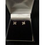 A pair of square cut diamond earrings