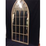 A tall arched outdoor mirror