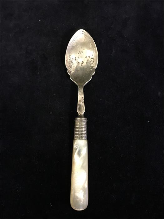 A mother of a pearl handled spoon