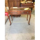 A walnut two drawer table on cabriole legs