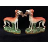 A pair of Staffordshire figures of Greyhounds with hare