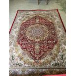 A Red ground rug unique woven silk floral medallion design 2.3m x 1.6m