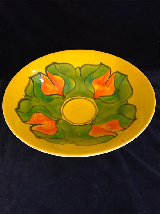 A Poole pottery Aegean large bowl, with yellow glaze and green and orange geometric flower