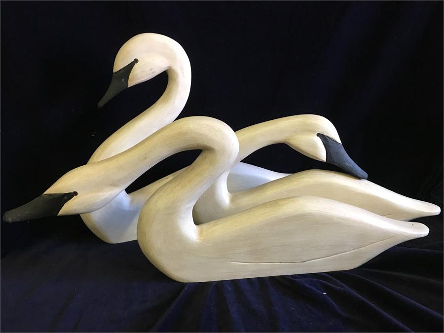 Three wooden decorative swans