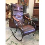 A cast iron and leather rocking chair