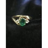 An emerald ring with diamond shoulders