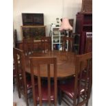 An eight seat circular dining table with lazy susan centre and eight high backed chairs with leather