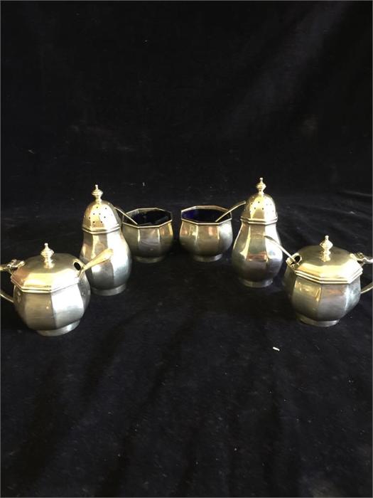 A silver cruet set of two peppers, two salts and two mustards