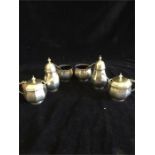 A silver cruet set of two peppers, two salts and two mustards