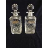 A Pair of crystal decanters with silver brandy and whisky labels.