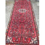 A red ground Persian runner with unique all over design 300 x 100