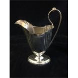 A silver milk jug by Walker and Hall, hallmarked Sheffield 1902