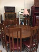 An eight seat circular dining table with lazy susan centre and eight high backed chairs with leather