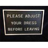 A Cast Iron Please Adjust Your Dress Sign