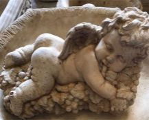 A garden stoneware cherub lying on a bed of grapes