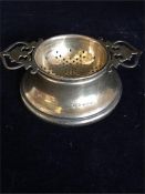 A silver tea strainer and stand, hallmarked Birmingham 1935 (62.3g)