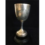 A silver, hallmarked, cup on an ebonised mount