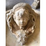 A stoneware garden wall mounted cherub's face planter