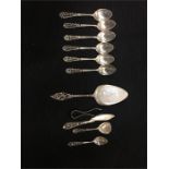 A volume of Dutch silver to include spoons, sugar nips, cake slice (Total weight 299.3g)