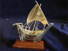 A silver sailing ship on a stand