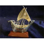 A silver sailing ship on a stand