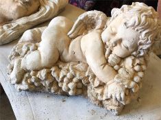 A garden stoneware cherub lying on a bed of grapes