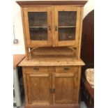 A Pine dresser with two drawers and cupboards under and two glass fronted cupboards above