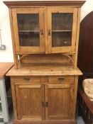 A Pine dresser with two drawers and cupboards under and two glass fronted cupboards above
