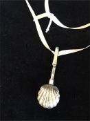 A silver shell style necklace on ribbon