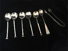 A selection of silver items to include five teaspoons, salt spoon and sugar tongs