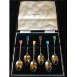 A Boxed set of silver and enamel teaspoons, Harrods.