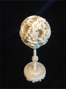 A worked ivory puzzle ball on a stand