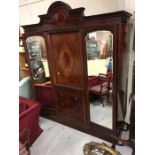 A Gentleman's wardrobe in mahogany with inlay, drawers, three cupboards and drawers.