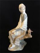 A Lladro figure of a lady in a shawl with a bird.