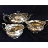 A silver tea set comprising tea pot, sugar bowl and milk jug, hallmarked London 1891-92 (933g)