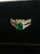 An Emerald and Diamond ring in an 18ct gold setting.