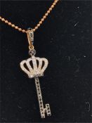 A Bespoke 18ct Rose Gold, Diamond Pave with Black Diamond crown key pendant, on a rose gold chain.