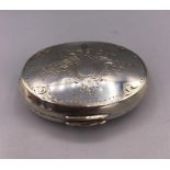 An oval silver pill box