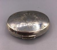 An oval silver pill box