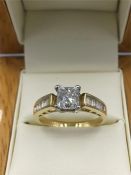 An 18ct yellow gold Diamond ring, the central stone of 90 points with diamond shoulders