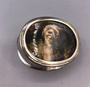 A White metal pill box with dog decoration