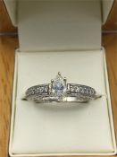 A 14ct white gold oval diamond with diamond shoulders