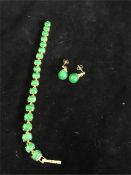 A Jade bracelet set in 9ct gold with a pair of Jade earrings