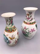 Two small Oriental hand painted vases with bird motif.