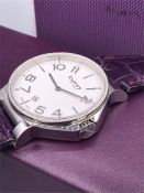 An Asprey pave diamond bezel watch on purple alligator strap.