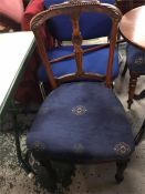 Set of four dining chairs with blue seat pads.